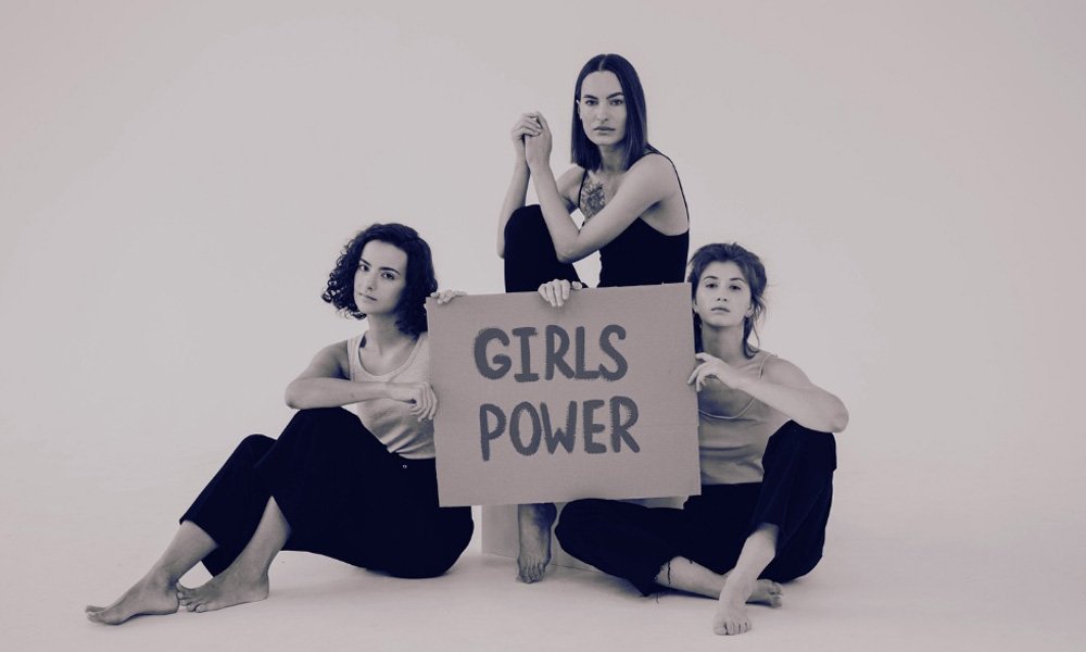 3 young women holding a GIRLS POWER sign
